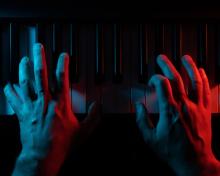 Hands on a piano keyboard